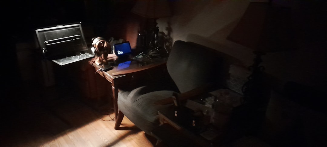 a-dimly-lit-room-with-a-desk-and-chair-o4x1ihwndvu